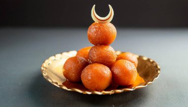 Bayram Mübarek ve Ramazan yaratıcı konsept tasarımı. Hindistan Tatlı Motichoor laddoo ve Gulab jamun tepesinde hilal var..