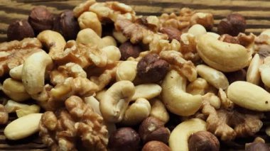 Mix of tasty nuts on a wooden surface. Cashews, almonds, hazelnuts and walnuts on a brown table.