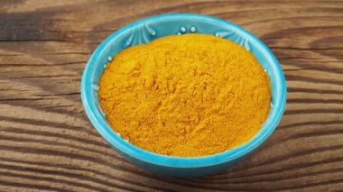 Curcuma powder in a small bowl on the table