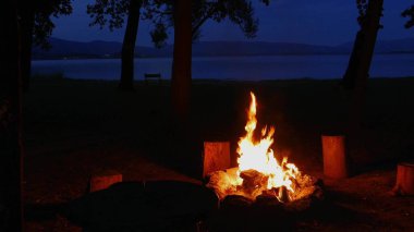 Kamp ateşinin harika akşam atmosferik arka planı. Küçük sihirli şenlik ateşinin güzel alevi.