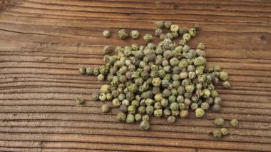 Dried green peppercorn. Dry green pepper spice on wooden table.