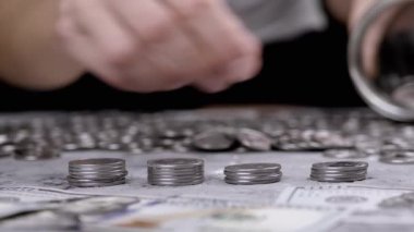 Glass Jar ya da Piggy Bank 'a Gümüş Para Yığını Koyan Kadın. Bir sürü sent, nakit para beton bir zeminde yatıyor. Bütçe, harcama, tasarruf, birikim. Zenginlik, yoksulluk. Mali işler. Stok.