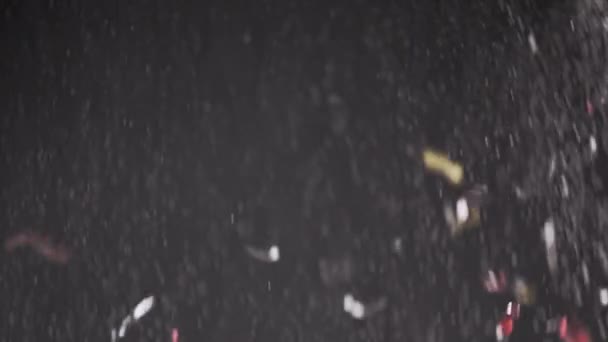 落下Confetti 塵粒子 および黒い背景の降雪の流れ チンセル 曇った霧の煙の中で白い粉を飛んでのぼやけた抽象的な動的背景 スターダスト花火 — ストック動画