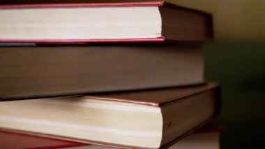 Güneş Işıkları 'ndaki Renkli Eski Hardcover Kitapları' nın yakın çekimi. Alttan kamera hareketi. Bulanık arka planda kitap koleksiyonu. Öğrenme, okuma ve bilgi kavramı.