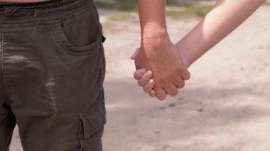 Çıplak Gövdeli ve Şortlu Baba Açık Hava 'dan Bir Çocuğu Tutuyor. Kapatın. El ele tutuşarak. Parkta dur. Ellerini sallıyorsun. Aşk, arkadaşlık, çocukluk. Aile yürüyüşü..