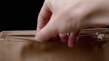 Kadın El, kahverengi deri çantadan 100 dolarlık banknot alıyor. Yakın plan. Cüzdandaki parayı kontrol ediyorum. Finansal harcamalar, harcamalar, alımlar, birikmiş tasarruflar. Amerikan parası. Siyah arkaplan.