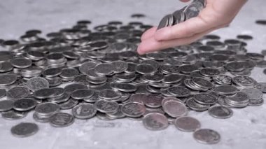 Bir avuç dolusu bozuk para Elden Masaya Dağılmış Kopek Yığını 'na düşer. Ukrayna gümüşü beş kopek sikkesi saçılımı. Para akışı. Finansal kriz, bütçe tasarrufu, para birikimi.