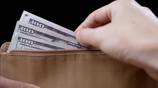ブラウンレザー財布から100ドル札を取る女性の手 それらを数える 接近中だ 財布の中の現金を確認する 蓄積された貯蓄 黒の背景 — ストック動画