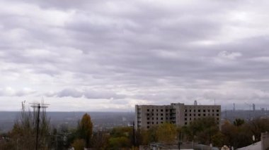 Terk Edilmiş Binanın Arkaplanına Karşı Gri Kümülüs Bulutları Taşımak. Şehrin kasvetli panoramik manzarası, fabrika ve rüzgarda sallanan ağaçlar. Sonbahar havası bulutlu. Ufuk. Doğa, kuşlar.