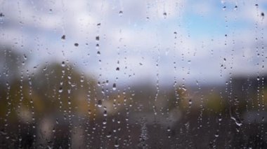 Bulutların Bulutların, Gökyüzünün, Doğanın Bulanık Arkaplanına Karşı Yağmur Damlaları Camdan Aşağı Akıyor. Yavaş çekim. Kümülüs bulutları hareket ediyor. Yağmurlu bir hava. Camdaki sisli su akıntıları pencereden aşağı akıyor. Meteoroloji.