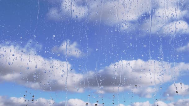 Dešťové Kapky Stékají Sklem Dolů Pozadí Pohybujících Mraků Modrého Nebe — Stock video