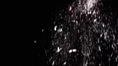 Düşen Konfeti Akıntısı, Toz Parçacıkları ve Kara Arkaplanda Kar Düşüşü. Bulanık soyut dinamik arka plan, uçan süsler, kar taneleri, beyaz toz. Yıldız yağmuru, kıvılcımlar, havai fişekler, meteorlar.