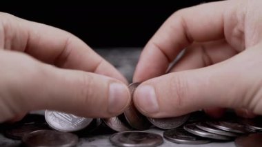 Bir Masanın Bulanık Arkaplanda Erkek Eller Sıralama ve Gümüş Paraları Sayma. Tanınmayan adam Ukrayna sentleri yatırıyor. Siyah arka plan. Dağınık paralar. Finansal kriz, bütçe tasarrufu.