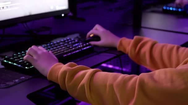 少年ゲーマーは 夜に仮想部屋でコンピュータに座って ビデオゲームをプレイ サイバースポーツクラブの仮想現実 Eスポーツの競争 ヘッドセット ネオンライト キーボード マウス 画面だ — ストック動画