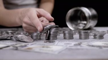 Kadın Parmaklar Gümüş Para Yığını 'ndan Kuleyi Yok Ediyor. Düşen, dağınık bozuk paralar, sentler. Finansal kriz. Bütçe, birikim, birikim. Çöküş, finans piyasası. Domuz kumbarası.