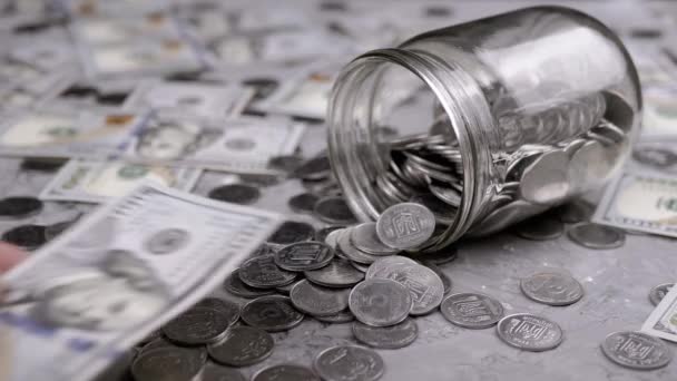 Рука Женщины Кладет 100 Долларовый Билл Стеклянную Банку Разбросанных Монет — стоковое видео