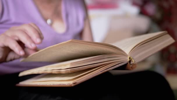 Пожилая Женщина Читает Книгу Переворачивает Страницы Лучах Солнечного Света Помещении — стоковое видео