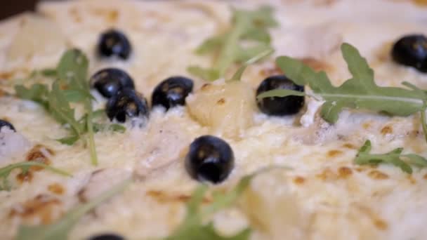 カフェの木製テーブルの上で調理されたイタリアのピザのクローズアップ 接近中だ オリーブ アルグラ パルメザン パイナップル ソーセージ キノコ サービス ピッツェリア — ストック動画