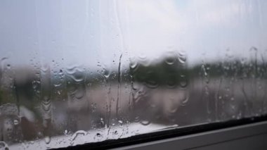 Yağmur Damlaları Pencerenin Dışındaki Islak Camdan Akıyor. Kasvetli gökyüzü, pencerenin dışında yağmurlu sonbahar havası. Meteoroloji. Mis gibi cam. Melankoli. Depresyon. Doğanın bulanık arkaplanı.