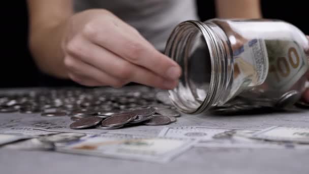 女人用银币和100美元钞票装玻璃瓶 小猪银行 乌克兰美分和现金都在一个具体的背景上 金融危机 — 图库视频影像