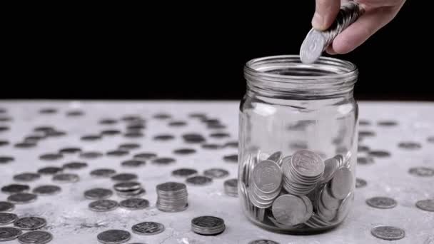 Handen Zet Een Handvol Geaccumuleerde Zilveren Munten Een Glazen Pot — Stockvideo