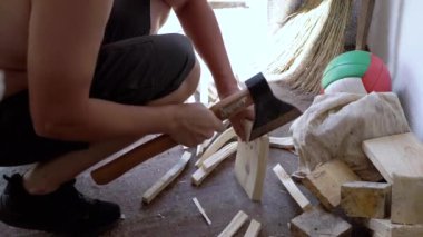 Güneş Işıkları 'nda garajda ağır bir baltayla erkek doğrama veya odun kesme. Kış için odun hazırlıyorum. Yan görüş. Tanımlanamayan kişi. Çöp, barakadaki envanter. Güneş ışını. İş.