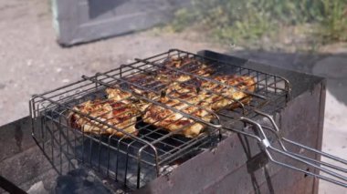 Izgara ızgarasında yanan ateşe ince bir su damlatan kişi. Sulu biftek pişirmek, dışarıda ızgara et yemek. Açık bir ateşi söndürmek. Duman, kül. Piknik. Hafta sonu. Kapat..