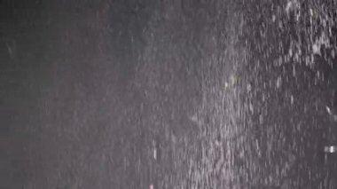 Düşen Konfeti Akıntısı, Toz Parçacıkları ve Kara Arkaplanda Kar Düşüşü. Bulanık soyut dinamik arka plan, uçan süsler, kar taneleri, bulutlu dumandaki beyaz toz. Kar fırtınası, havai fişek.