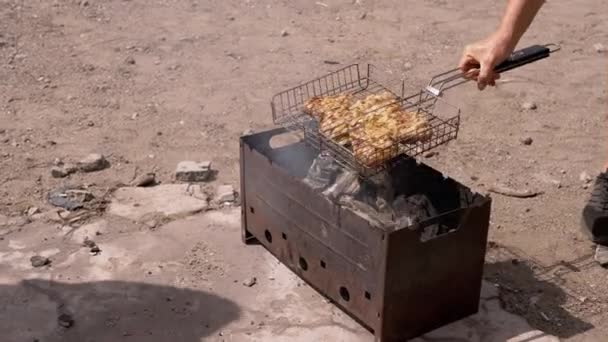 男性はグリルでジューシーな肉を調理します 日光の光線で裏庭にバーベキュー 調理料理オープン火災でケバブ 静止グリル 灰と熱い石炭のストーブ 金属グリル — ストック動画