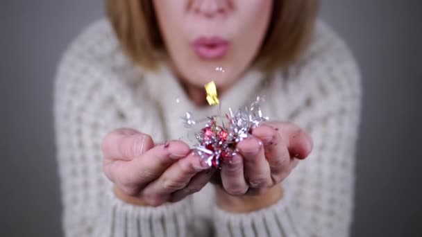 Happy Woman Blowing Shiny Kleurrijke Confetti Handen Een Wazige Achtergrond — Stockvideo