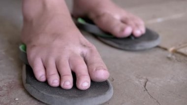 Zavallı Çocuk Kirli Çıplak Ayaklar, Kıpırdayan Parmaklar, Rahatlama Egzersizleri. Yorgun çocukların parmak ve bacaklarını parmak arası terliklerle yakın plan çek. Yorgun, evsiz bir genç, paslı bir garajda dinleniyor..
