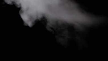 Icy White Foggy Cloud of Flying Steam on a Black Background. Abstract background. Bokeh effect. Thick fog and smoke fill the empty space. Blurred focus. Ice cloud steam. Floating mist. Slow-motion.