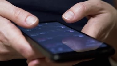 Investor Checks Price of Cryptocurrency on Touch Screen of a Mobile Phone. Fingers touch screen of a smartphone. Mobile app. Cryptocurrency pairs, bitcoin. Stock exchange data. Growth, fall of crypto.