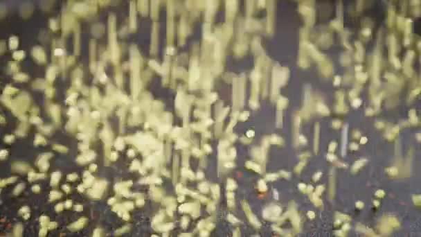 阳光照射下黑色表面上小米槽下落的黄粒流 炸成圆形的小球 在煎锅里的金粉颗粒 模糊的食物背景 恶心死了结构 — 图库视频影像