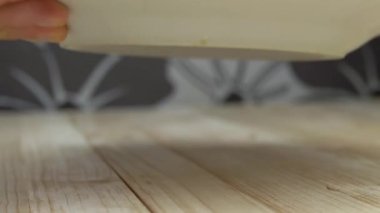 Garsonun eli, Shawarma 'yla birlikte Ahşap Masa' da sandviç servisi yapıyor. Sulu kızartma, taze domates, peynir, havuç ve sosla doldurulmuş bir tabakta pide ya da pide. Fast food servisi. Kafe.