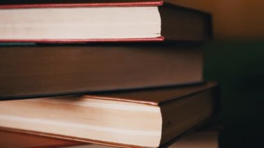 Güneş Işıkları 'ndaki Renkli Eski Hardcover Kitapları' nın yakın çekimi. Alttan kamera hareketi. Bulanık arka planda kitap koleksiyonu. Öğrenme, okuma ve bilgi kavramı.
