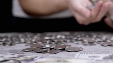 Kadın, Cam Kavanoz 'dan Birikmiş Gümüş Para Yığını Bir Masaya Döker. Gri beton arka planda bir sürü bozuk para var. Finansal kriz, bütçe, tasarruf, para birikimi. Sayıyorum. Yoksulluk.