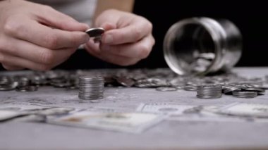Dişi Eller, Scattered Money yakınlarındaki bir para yığınından bir kule inşa ediyor. Cam kavanoz, kumbara. Bir senti kulenin tepesine koyuyor. Bütçe, birikim, birikim. Zenginlik, yoksulluk. Ekonomik kriz.