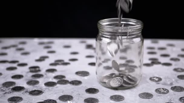 Stříbrné Mince Spadají Skleněné Sklenice Pozadí Roztroušených Kopějek Prasečí Banka — Stock video