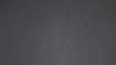 Düşen Karışık Toz Parçacıkları, Enkaz Akıntısı, Kara Arkaplanda Toz. Kar yağışı. Beyaz karın dinamik parçacıkları döner, kıvrılır ve bulut sisinde yüzer. Yıldız yağmuru, yıldız tozu. Boşluk.