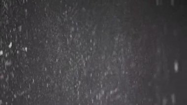 Düşen Konfeti Akıntısı, Toz Parçacıkları ve Kara Arkaplanda Kar Düşüşü. Bulanık soyut dinamik arka plan, uçan süsler, kar taneleri, bulutlu dumandaki beyaz toz. Yıldız tozu, havai fişekler.