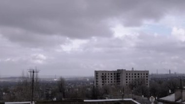 Terk Edilmiş Binanın Arkaplanına Karşı Gri Kümülüs Bulutları Taşımak. Şehrin kasvetli panoramik manzarası, fabrika ve rüzgarda sallanan ağaçlar. Sonbahar havası bulutlu. Ufuk. Doğa, kuşlar.