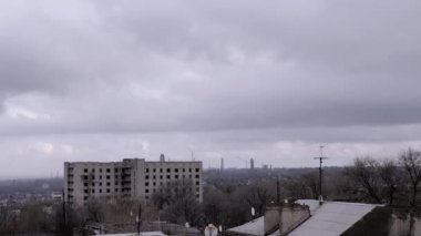 Terk Edilmiş Binanın Arkaplanına Karşı Gri Kümülüs Bulutları Taşımak. Şehrin kasvetli panoramik manzarası, fabrika ve rüzgarda sallanan ağaçlar. Sonbahar havası bulutlu. Ufuk. Doğa, kuşlar.