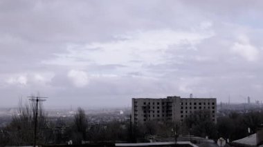 Terk Edilmiş Binanın Arkaplanına Karşı Gri Kümülüs Bulutları Taşımak. Bitmemiş ev. Kasvetli panoramik şehir, fabrika ve rüzgarda sallanan ağaçlar. Sonbahar havası bulutlu. Ufuk.