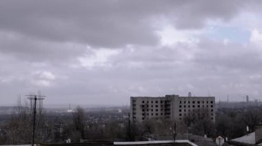 Terk Edilmiş Binanın Arkaplanına Karşı Gri Kümülüs Bulutları Taşımak. Şehrin kasvetli panoramik manzarası, fabrika ve rüzgarda sallanan ağaçlar. Sonbahar havası bulutlu. Ufuk. Doğa, kuşlar.