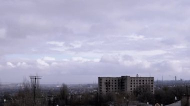 Terk Edilmiş Binanın Arkaplanına Karşı Gri Kümülüs Bulutları Taşımak. Şehrin kasvetli panoramik manzarası, fabrika ve rüzgarda sallanan ağaçlar. Sonbahar havası bulutlu. Ufuk. Doğa, kuşlar.