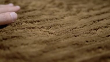 Kahverengi Yumuşak Yün Battaniyeye Elle Dokunan Kız. Yakın plan. Elin rahat bir battaniyenin yüzeyinde kayması. Doku, arkaplan, halının kısa yığın yapısı..