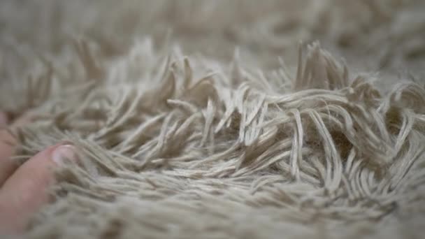 女孩用手触摸米色柔软温暖羊毛毛毯的表面 手在舒适的毛毯表面上滑动的动作 地毯的结构 长堆结构 — 图库视频影像