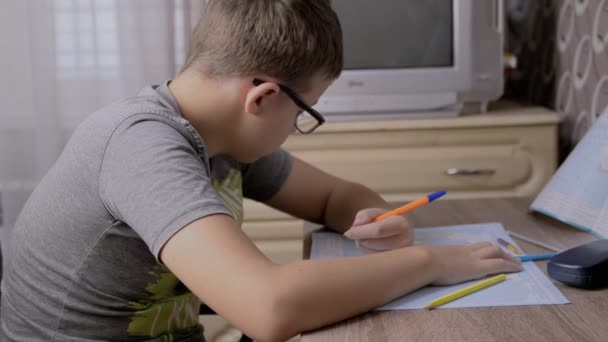 Серйозний Хлопчик Окулярах Написання Карті Світу Ручкою Сумний Школяр Сидить — стокове відео