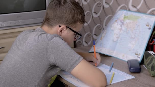 Gözlüklü Ciddi Çocuk Dünya Haritasında Kalemle Yazıyor Üzgün Bir Okul — Stok video